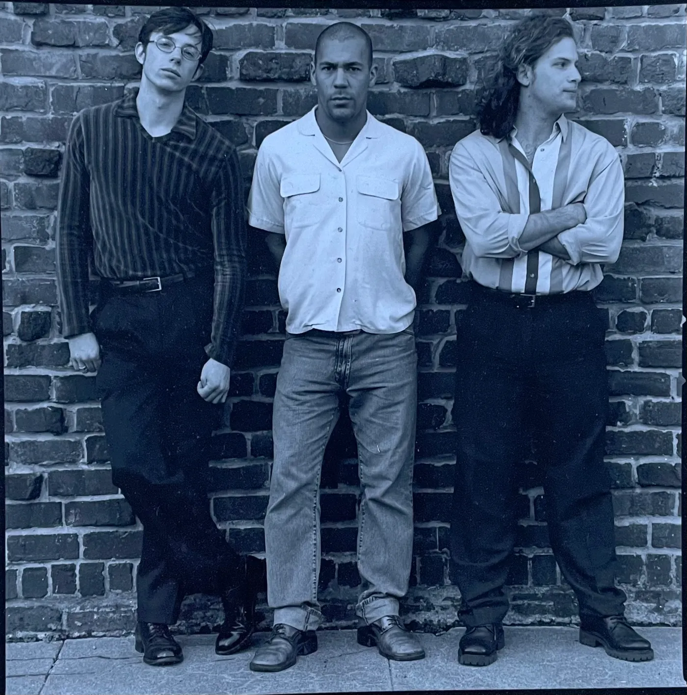 Simple Charlie’s three founders leaning against a brick wall, 1998